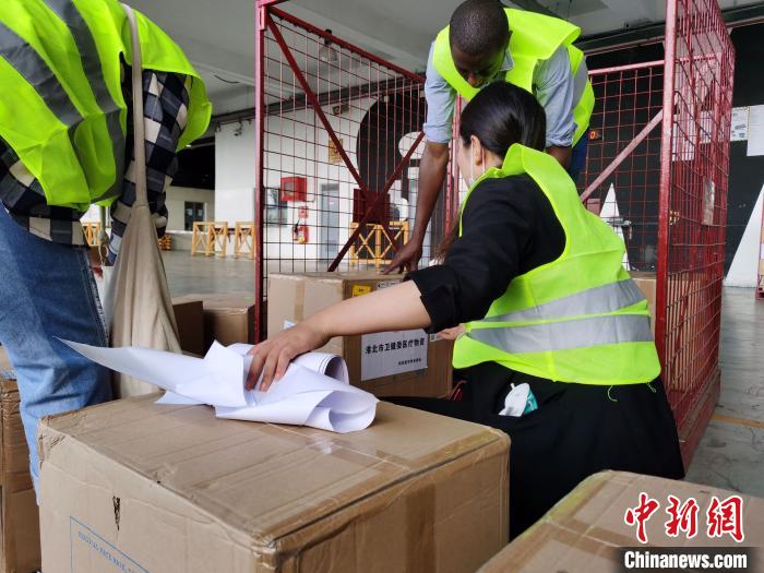 肯尼亚中华总商会秘书处刘静协助肯方机场工作人员托运物资 钟欣 摄