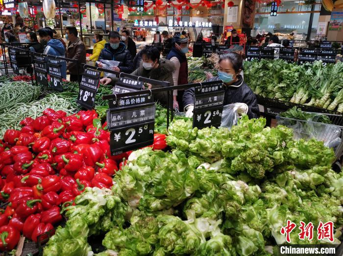 图为重庆超市生活用品供应充足，市民戴口罩挑选蔬菜。　周毅　摄